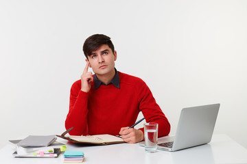 Office photo of manager draws up his schedule, remembered an important matter meeting that needs to be planned, pen in left hand,good thought comes to mind, looks up and pointing index finger upwards