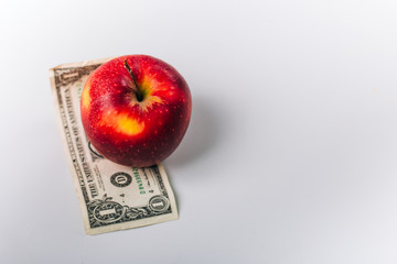 apples on money. Fruit stand on a white table. Dollars under red apples