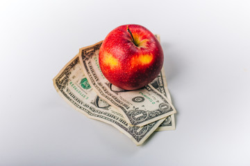 apples on money. Fruit stand on a white table. Dollars under red apples