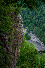 отвесная скала на фоне реки и лесом в Краснодарском крае