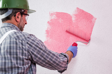 Professional house painter at work painting the wall © francescomou