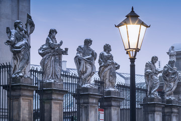 Fototapeta premium sculptures of saints on the street with night lighter in Krakow in Poland
