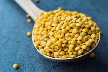 Yellow Lentils in Wooden Spoon.