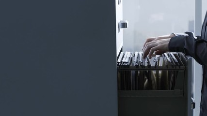 Female secretary searching files in the archive