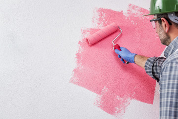 Professional house painter at work painting the wall © francescomou