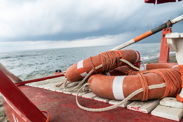 Orange life preserver rings with ropes on a rescue rowing catamaran