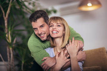 Fototapeta premium Loving young couple hugging and relaxing on sofa at home, selective focus.
