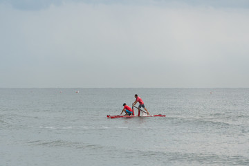 Two lifeguards on a rescue rowing catamaran in the sea