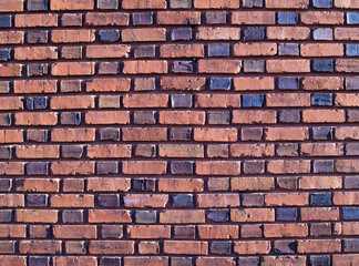 Multi-colored and duo-sized, old exterior brick wall.