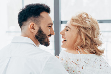 Laughing couple looking at each other with love