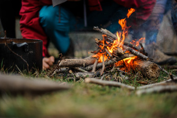 Man standing near the campfire in the forest