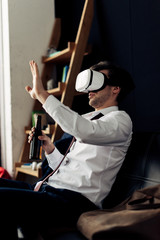 man wearing virtual reality headset and holding bottle of beer