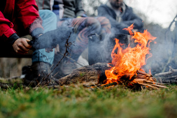 Man waving a blow on the pan on the bonfire
