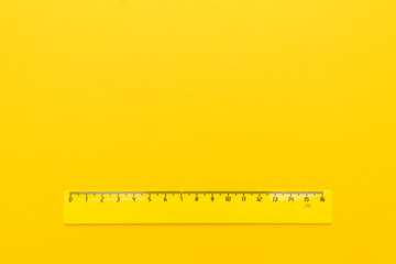 yellow plastic ruler on the yellow background