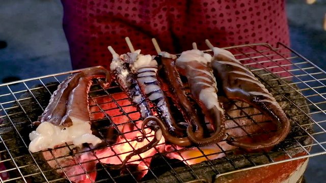 Grill fresh raw tentacle Octopus on griller for snack street food Mae Hong Son