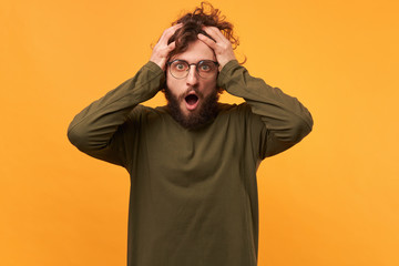 Oh my God, disaster, man in glasses opened mouth in panic, isolated on a yellow background. Guy...