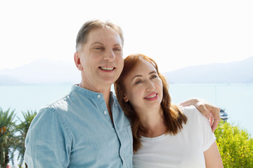 Obraz premium Summer family vacation. Happy middle aged couple having fun on travel holidays weekend. Sea and beach background. Copy space.