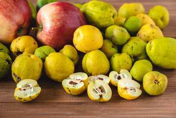 Fresh organic quince and apples from the garden on a wooden table.