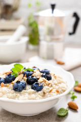 Oatmeal with fresh blueberry, almond nuts and honey for breakfast