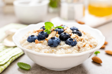 Oatmeal with fresh blueberry, almond nuts and honey for breakfast - obrazy, fototapety, plakaty