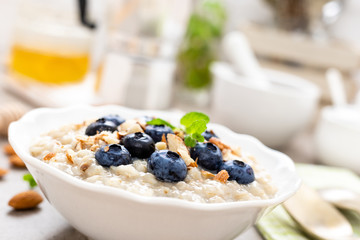 Oatmeal with fresh blueberry, almond nuts and honey for breakfast