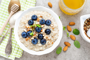 Oatmeal with fresh blueberry, almond nuts and honey for breakfast