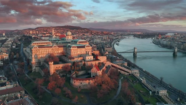 Budapest, Hungary - 4K flying over Buda Castle Royal palace on a sunny winter day towards Szechenyi Chain Bridge and Parliament at sunrise