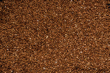 Buckwheat on the black background with a hand
