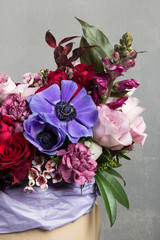 beautiful bouquet in box, gift bouquet of rare and juicy flowers, on a gray blurred background