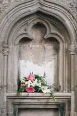 Fototapeta na wymiar Colorful bouquet resting in a church alcove