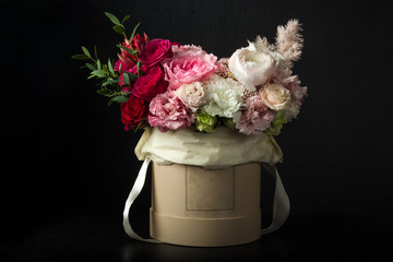 beautiful bouquet of flowers in a box on a black background, fresh exclusive flowers in a bouquet.