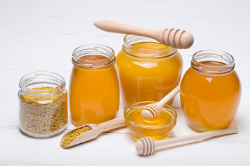 honey dipper and honey in jar on white background