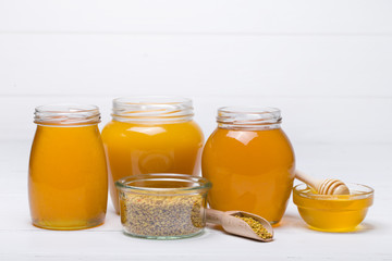 honey dipper and honey in jar on white background