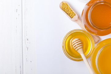 Fototapeta na wymiar honey dipper and honey in jar on white background