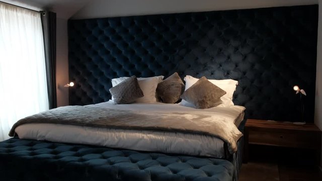 Dark blue bed, bedroom interior. Soft pillows on the bed