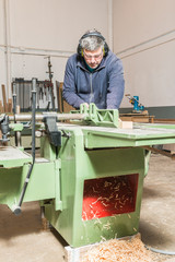 Fototapeta premium Male carpenter working in his carpentry workshop.