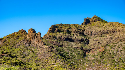 Fototapeta na wymiar In Santiago del Teide am Fuße des Vulkans Teide nordwestlich des Teno Gebirges erwartet Dich eine einzigartige Landschaft. Es gibt zahllose Wanderwege, an denen Palmen, Kakteen sowie Agaven wachsen. 