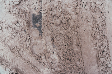 Snow starting to fall i bits as it melts on top of a asphalted road, seen from above