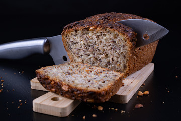 Tasting bread with seeds on a wooden board. Fresh dark bread on the kitchen table.