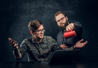 Programmer will lose his mind after a long and hard work in the office and began to pour coffee on...