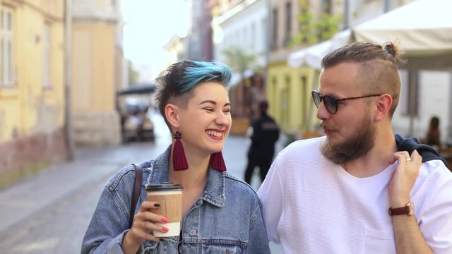 couple of hipsters guy with glasses girl with coffee go talking about something