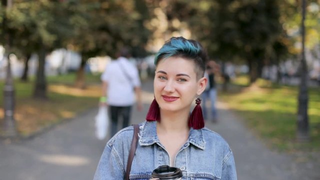 beautiful girl with a punk hairstyle, jeans jacket, portrait, the camera is moving away, slow motion