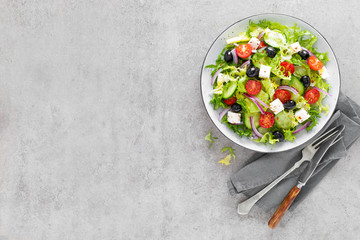 Vegetable salad with fresh cucumber, tomato, olive, onion, lettuce and feta cheese. Healthy food. Top view
