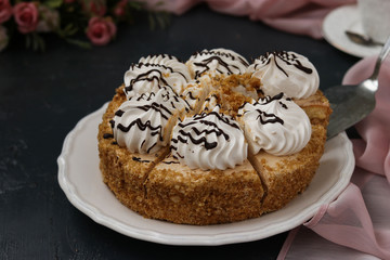 Honey sponge cake with butter cream located on a dark background