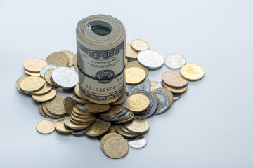100 dollar bills twisted into tube and tied with an elastic band. white background.