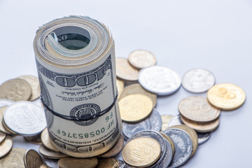 100 dollar bills twisted into tube and tied with an elastic band. white background.