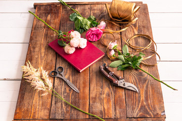 The workplace of the florist to work. Side view. Making floral decorations. Flowers on a old wooden table. Tools and accessories florists need for making up a bouquet.