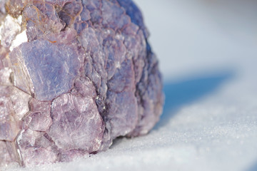 Rough Purple Lepidolite cluster from Brazil on white snow at a sunny winter day. Lepidolite Mica Slices.