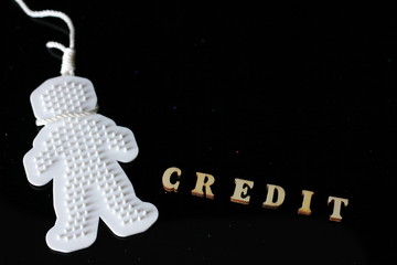 A CREDIT word is laid out wooden letters. Credit history and suicide. Credit crunch and credit...