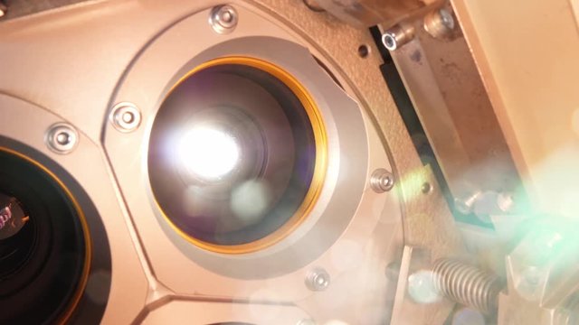 Film runs through a 35mm projector in a movie theater
